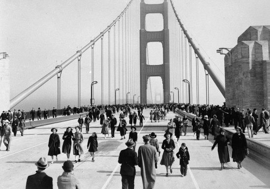 A good day for a black and white photo of people walking across the Golden Gate Bridge.