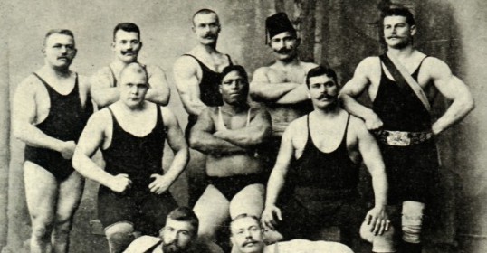 A group of strong wrestlers posing for a photo.
