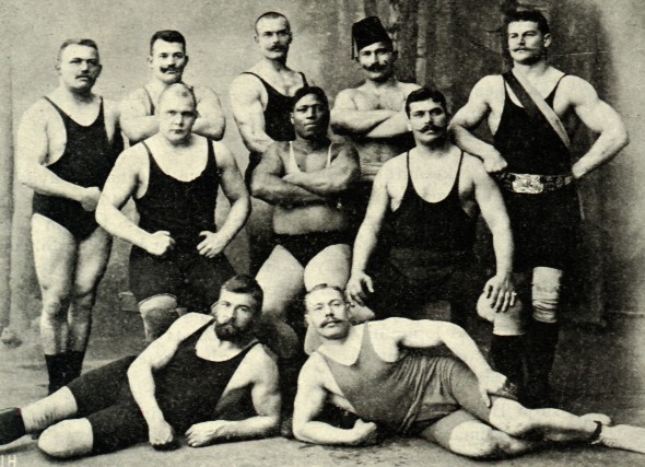 A group of strong wrestlers posing for a photo.
