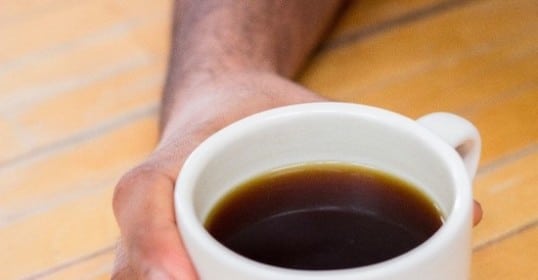 A hand holding a coffee mug.