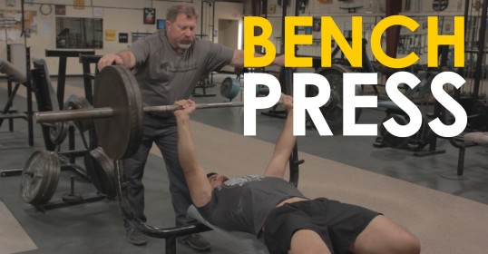 A man, bench pressing at the gym.