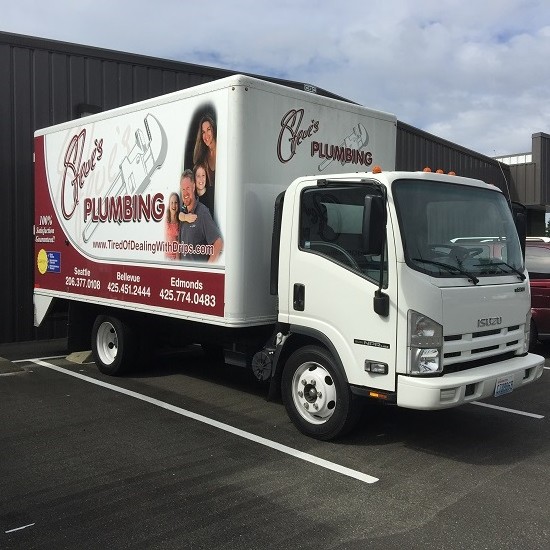 A white truck parked in front of a building.