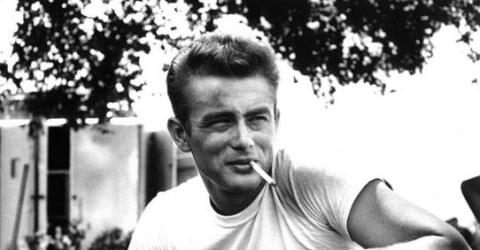 A black and white photo of a man smoking a cigarette.