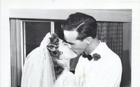 An old black and white photo of a bride and groom kissing, capturing the surprising moment.