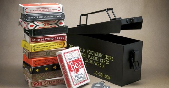 A stack of cards and other items atop a box, a classic groomsmen gift.