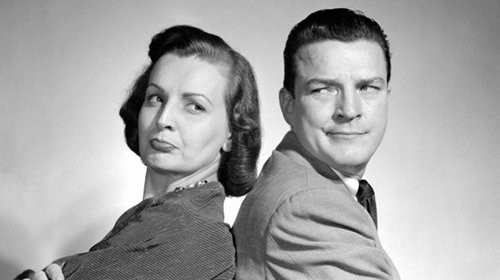 A black and white photo of a man and woman posing together.
