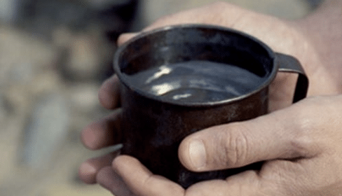 A man's hands holding a mug of water, experiencing a simple miracle.