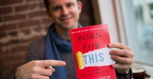 A man holding up a book called 