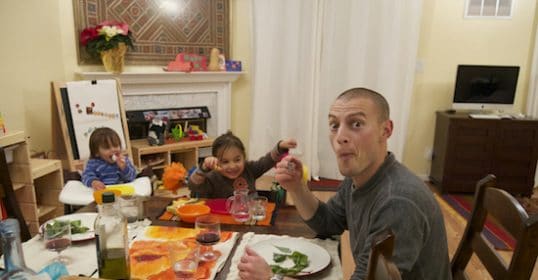 A family enjoys pizza together at the table.