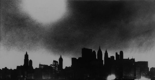 A black and white photograph of a city skyline.