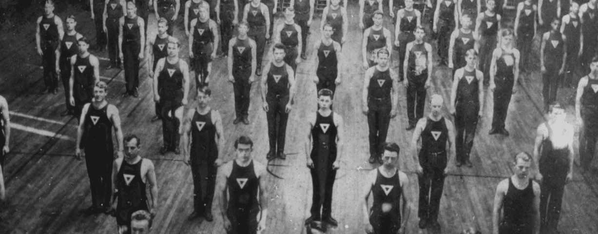 A black and white photo of a muscular group of men.