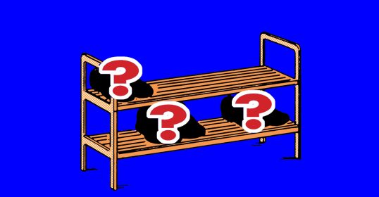 A wooden shelf with question marks, perfect for a man's minimalist wardrobe of shoes.