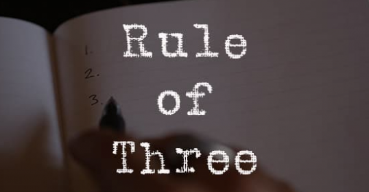 A person writing in a notebook with the phrase 
