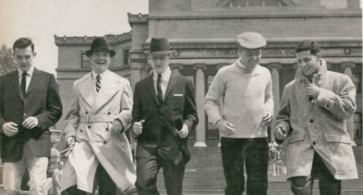A group of men in suits walking down steps.