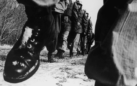 A group of soldiers participating in the JFK 50-Mile Challenge walk down a path.