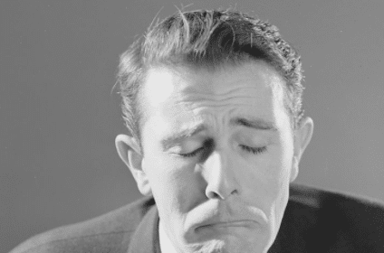 A black and white photo of a man with his eyes closed exuding an aura of negativity.