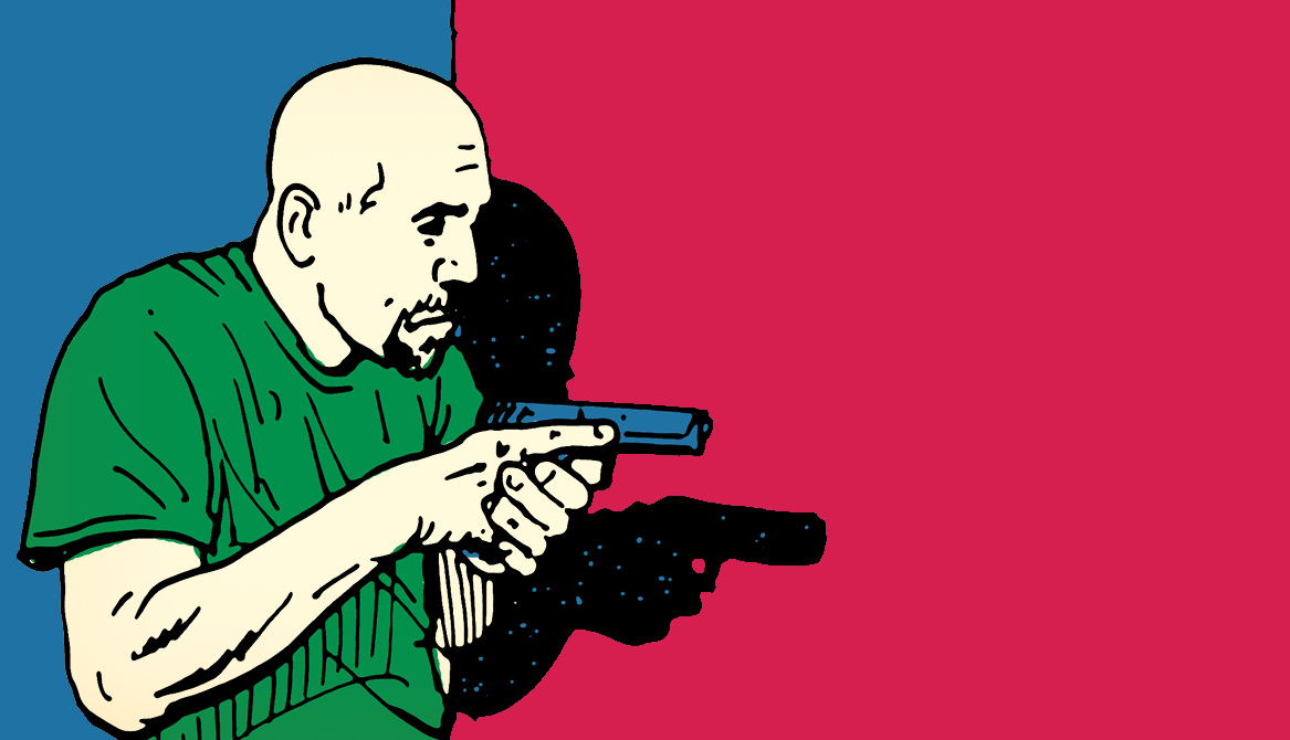 A man holding a gun in front of a clear wall.
