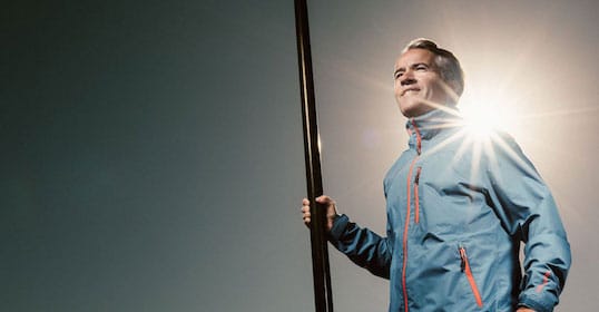 An adventurer standing in the sun with a pole.