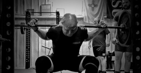 A man rehabbing from an injury in a crossfit gym.