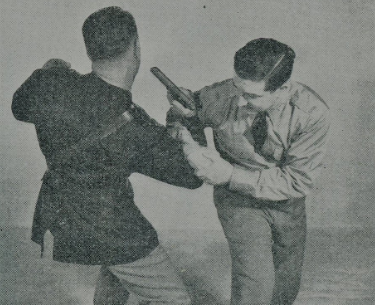 Two men in uniform engaged in unarmed combat during WWII.