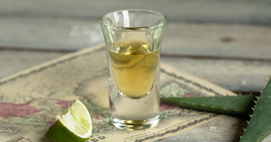 A shot of tequila with a slice of lime, perfect for a man.