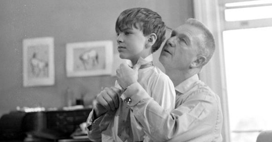 A father helping his son with tie style.