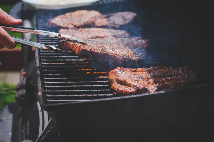 A person is grilling the perfect steak on a grill.