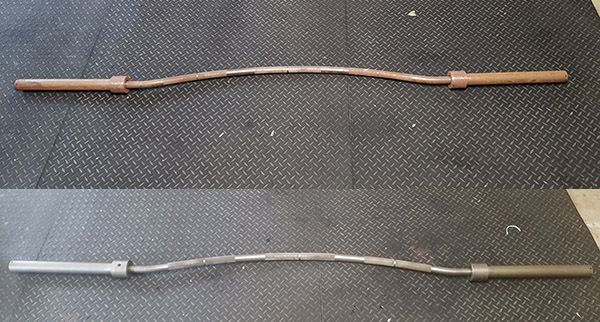 A pair of barbells on a black mat.