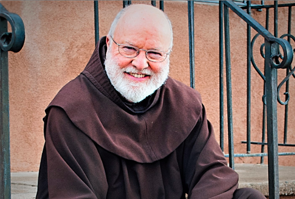 A man in a brown robe sitting on steps, pondering his journey.