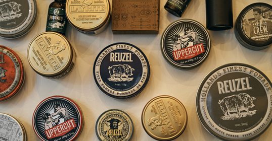 On the wall, various tins of beard products are showcased for customers to choose from.