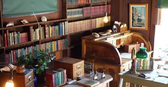 A room lined with books and a desk, reminiscent of libraries.