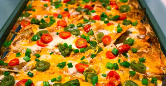 Elevate your nachos with fresh tomatoes and peppers.