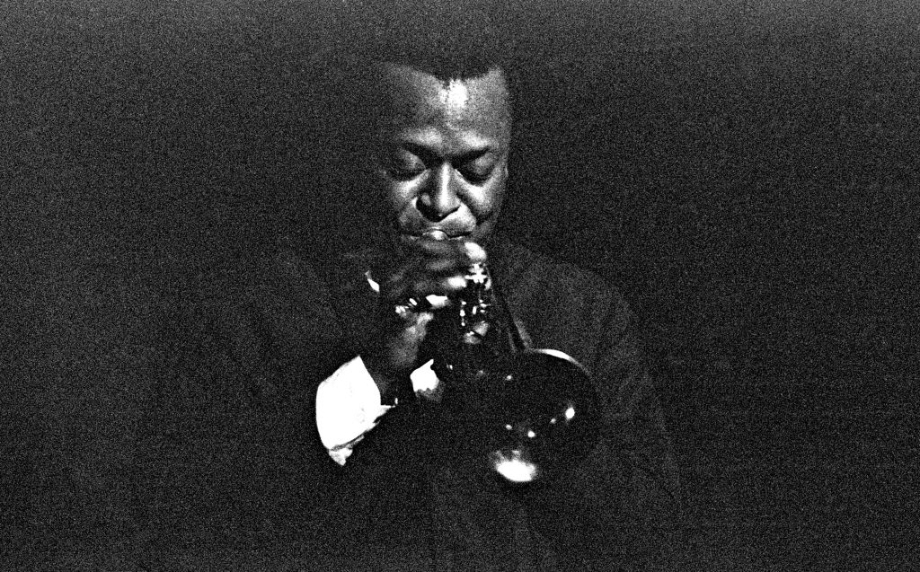 A black and white photo of a man playing a trumpet, perfect for those who enjoy jazz music.