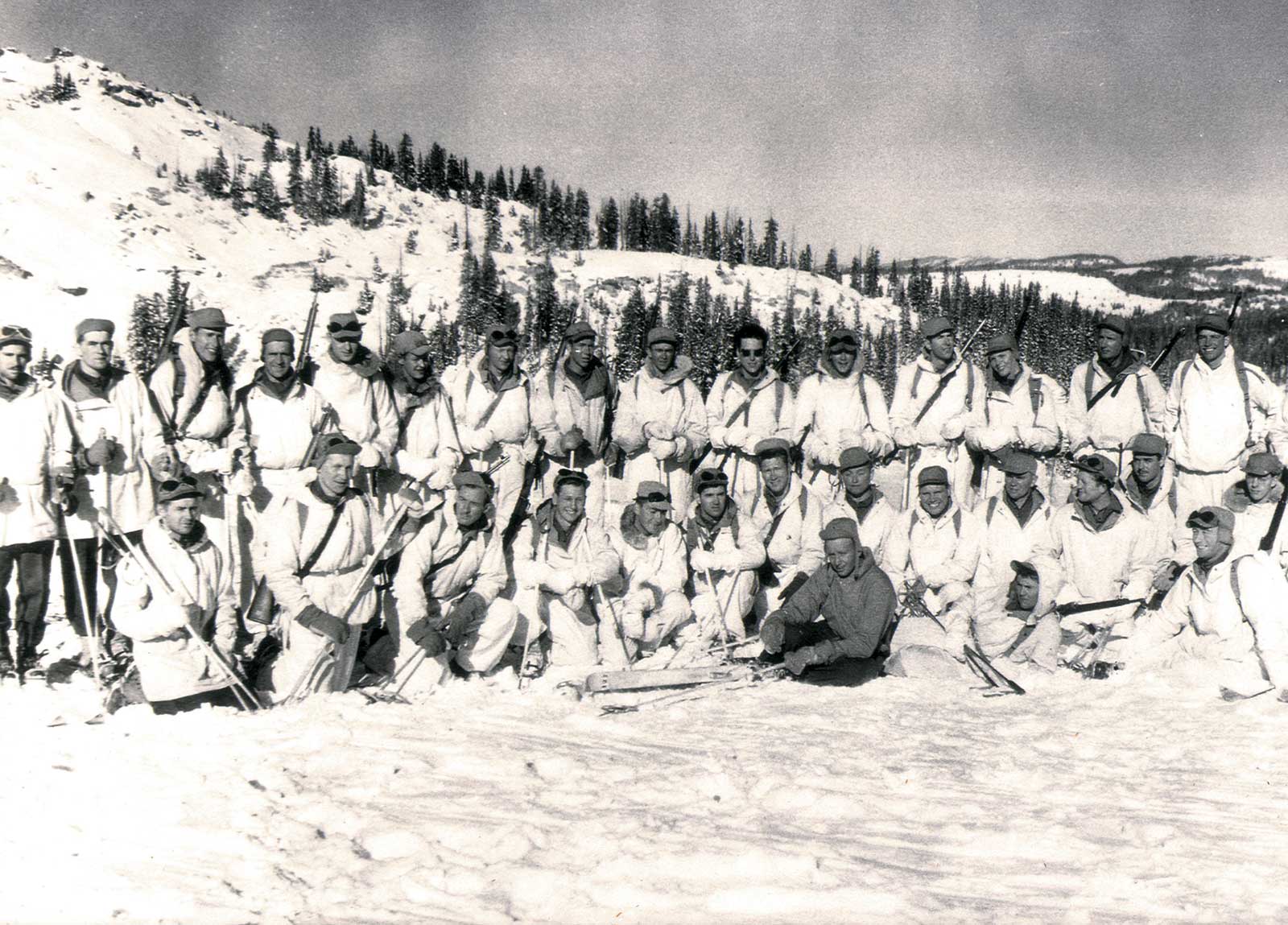 A group of skiing soldiers posing for a photo.