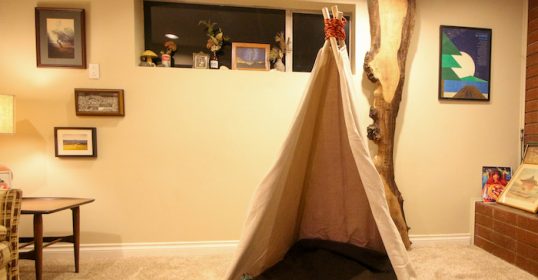 A teepee crafted by kids sits in the living room.