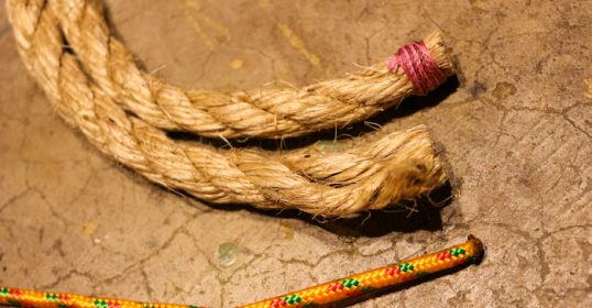 Two ropes on a concrete surface, intertwined like a fuse.