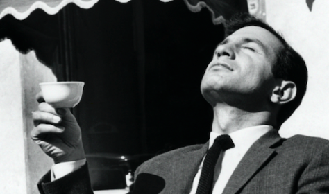 An important man in a suit holding a cup of coffee.