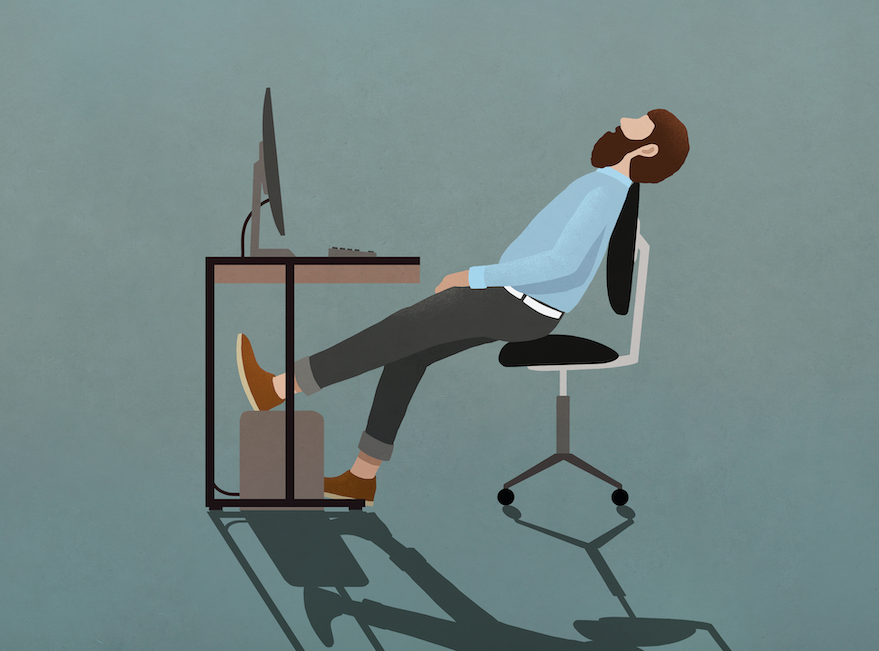 A man sitting at a desk while working from home with his legs crossed.