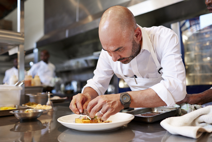A chef in the kitchen, organizing food.