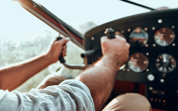 A man is in the cockpit of a plane, taking responsibility for the controls.