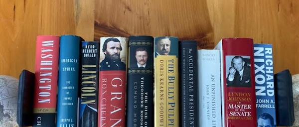 A stack of biographies on an American President, resting on a wooden table.