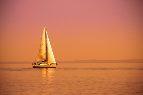 A sailboat on the water at sunset makes your life relaxing and effortless.