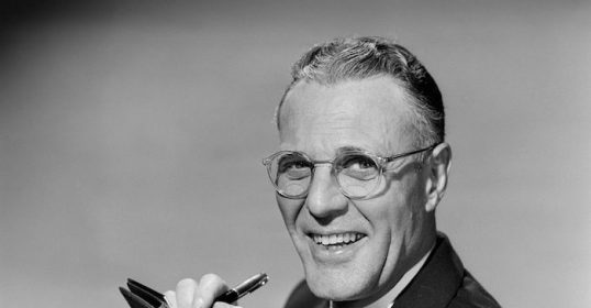 A black and white photo of a man holding a pen, showcasing his power.