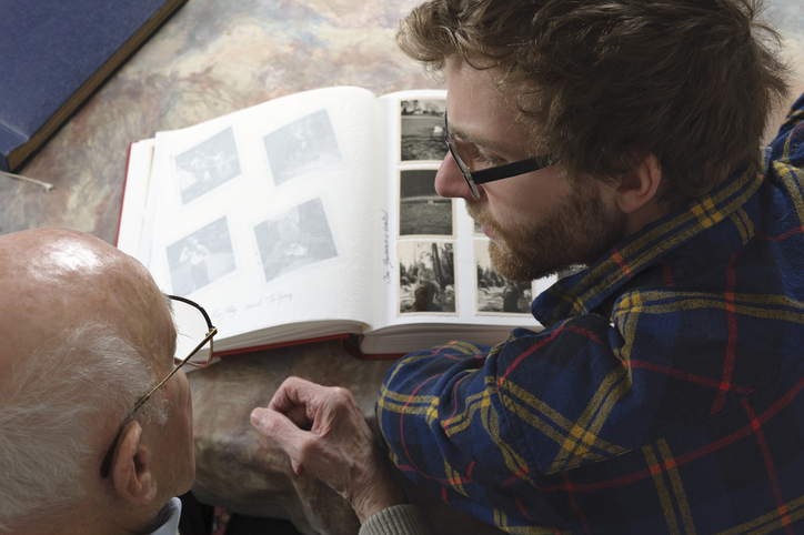 A man sitting at a table, deeply engrossed in a book.