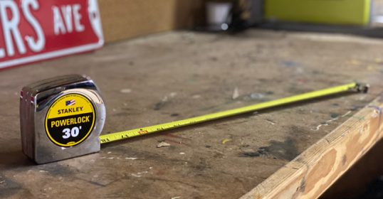 A trusty tape measure rests on the wooden table.