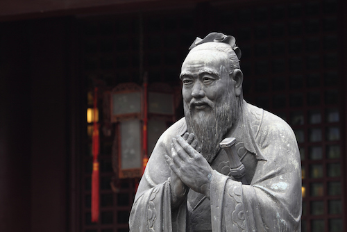 A statue of a Chinese man with a beard, resembling a Confucian gentleman.