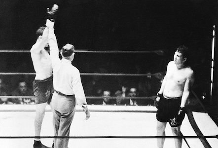 A black and white photo of two boxers in a boxing ring captures the intensity of the match.
