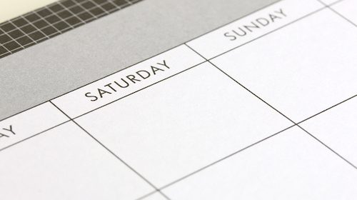 A close up image of a calendar on a desk featuring the Take Back the Weekend logo.