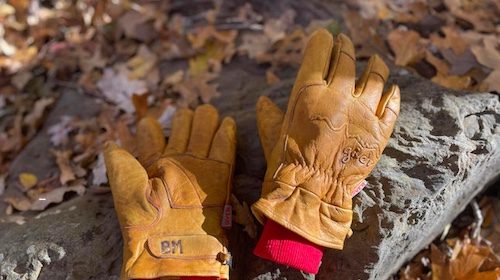 A pair of brown leather gloves resting on a rock - Last Pair needed.