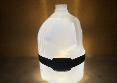 A bottle of water with a lantern attached to it, perfect for illuminating dark spaces.